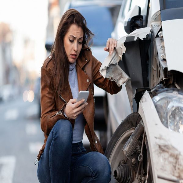 woman looking at her car after an accident
