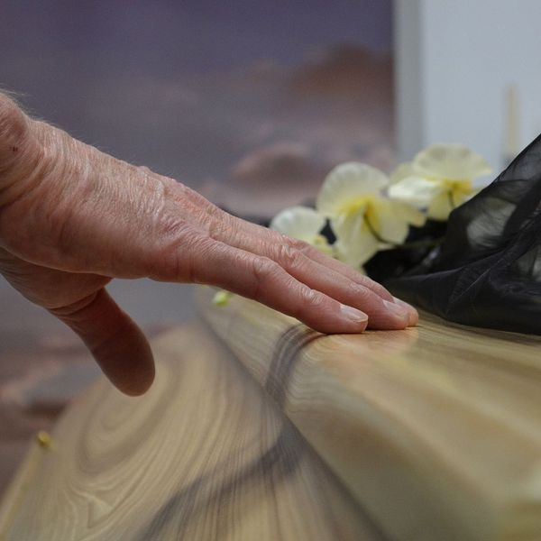 hand resting on a casket