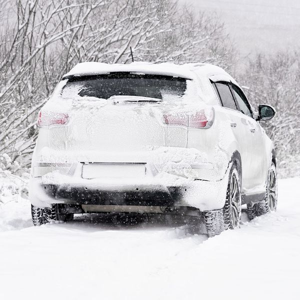 White suv driving through snow