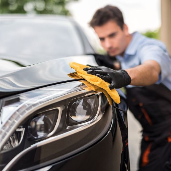 technician wiping down a car