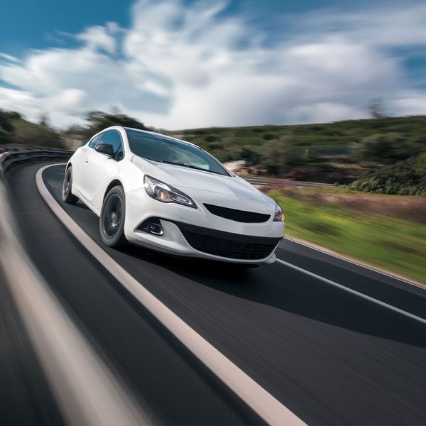 white sports car driving fast on a highway