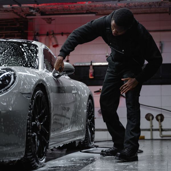 A professional washing a luxury car