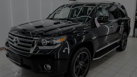 A freshly waxed dark SUV gleaming under studio lights.
