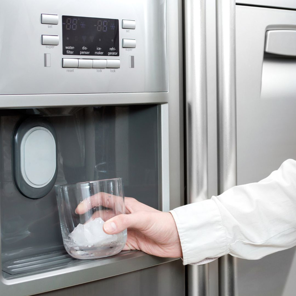 A person getting water from the fridge