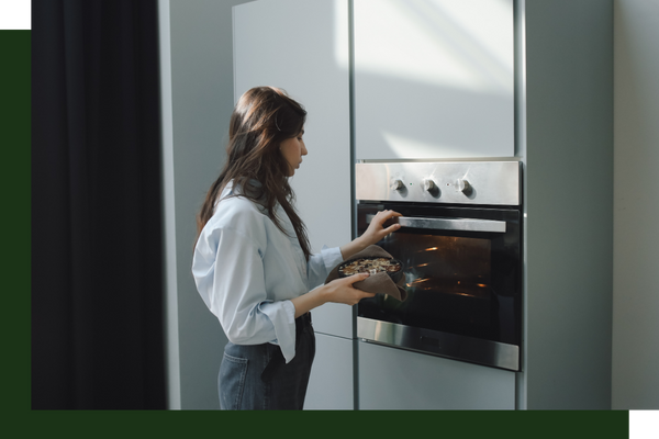 woman putting food into oven