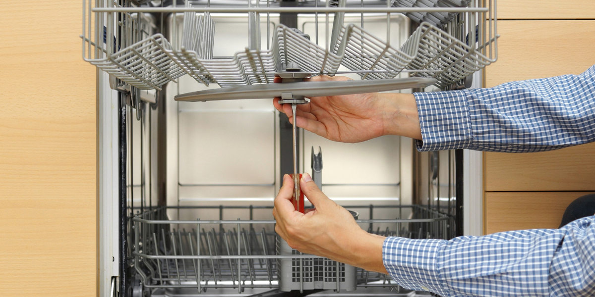 repair man working on dishwasher