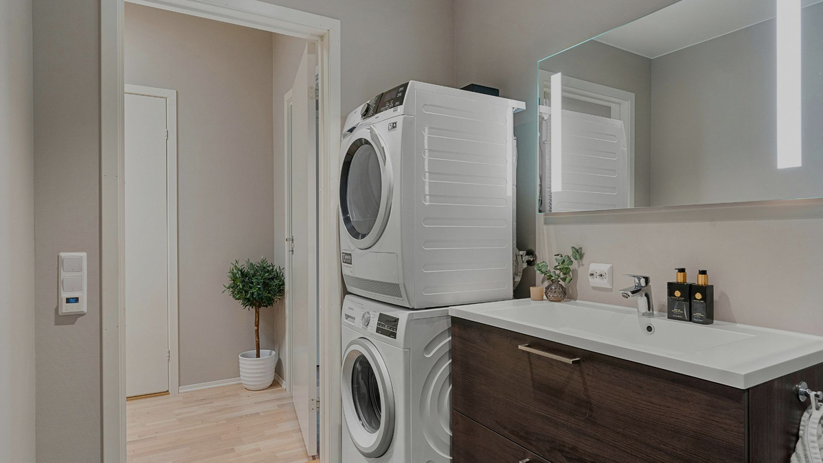 stacked washer and dryer in laundry room