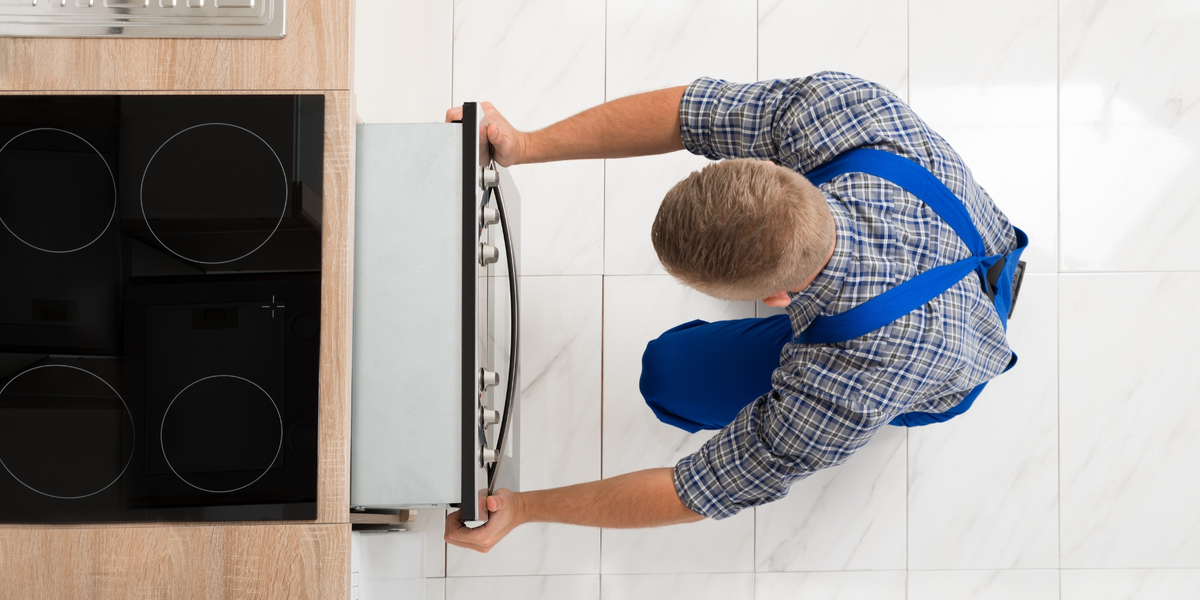 repair man working on dishwasher