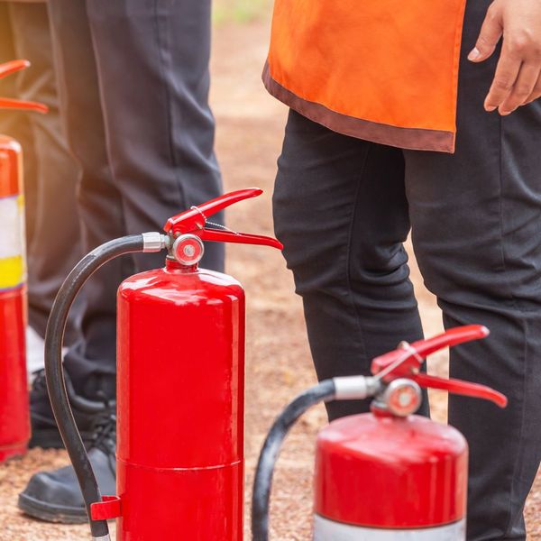 employees gathered outside with fire extinguishers