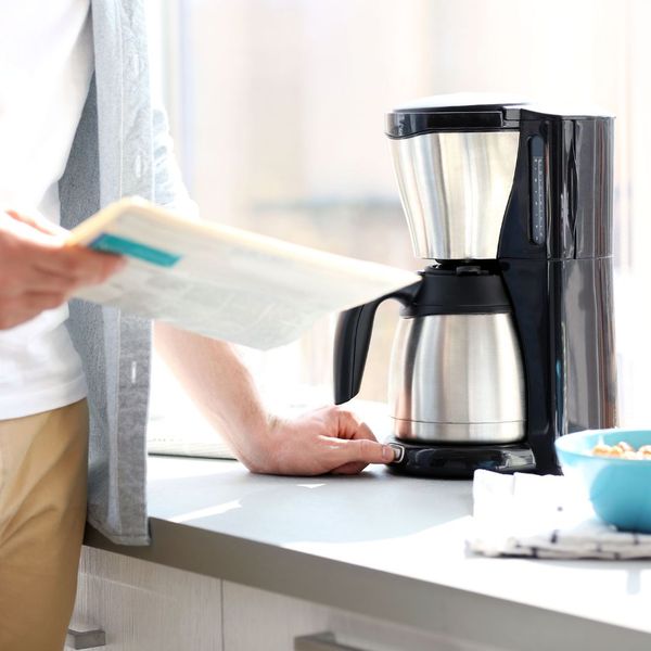 person using coffee maker