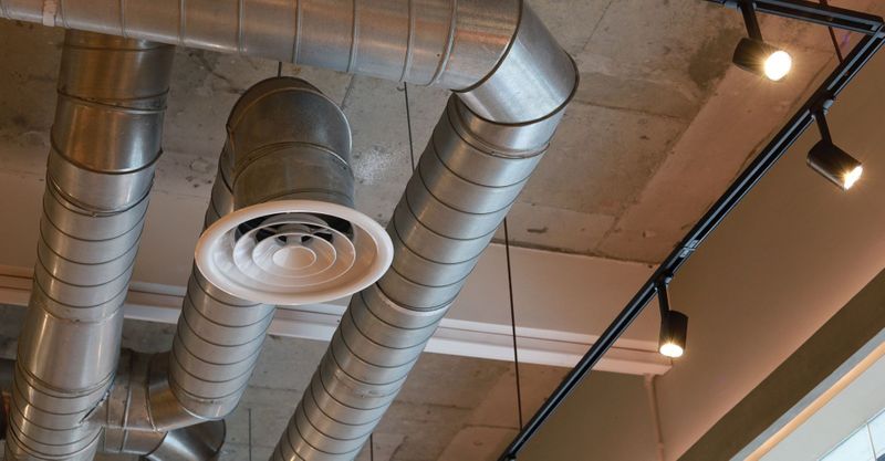 Exposed HVAC ductwork with modern lighting fixtures