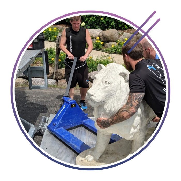 gorilla movers carefully transporting lion statue 