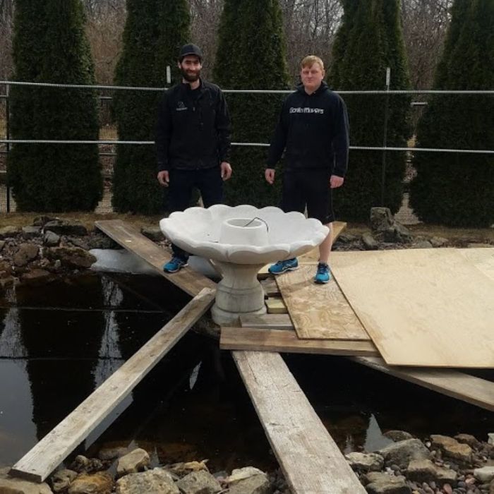 Two men standing beside a fountain under construction