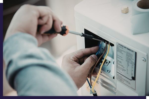 person servicing electric panel of appliance