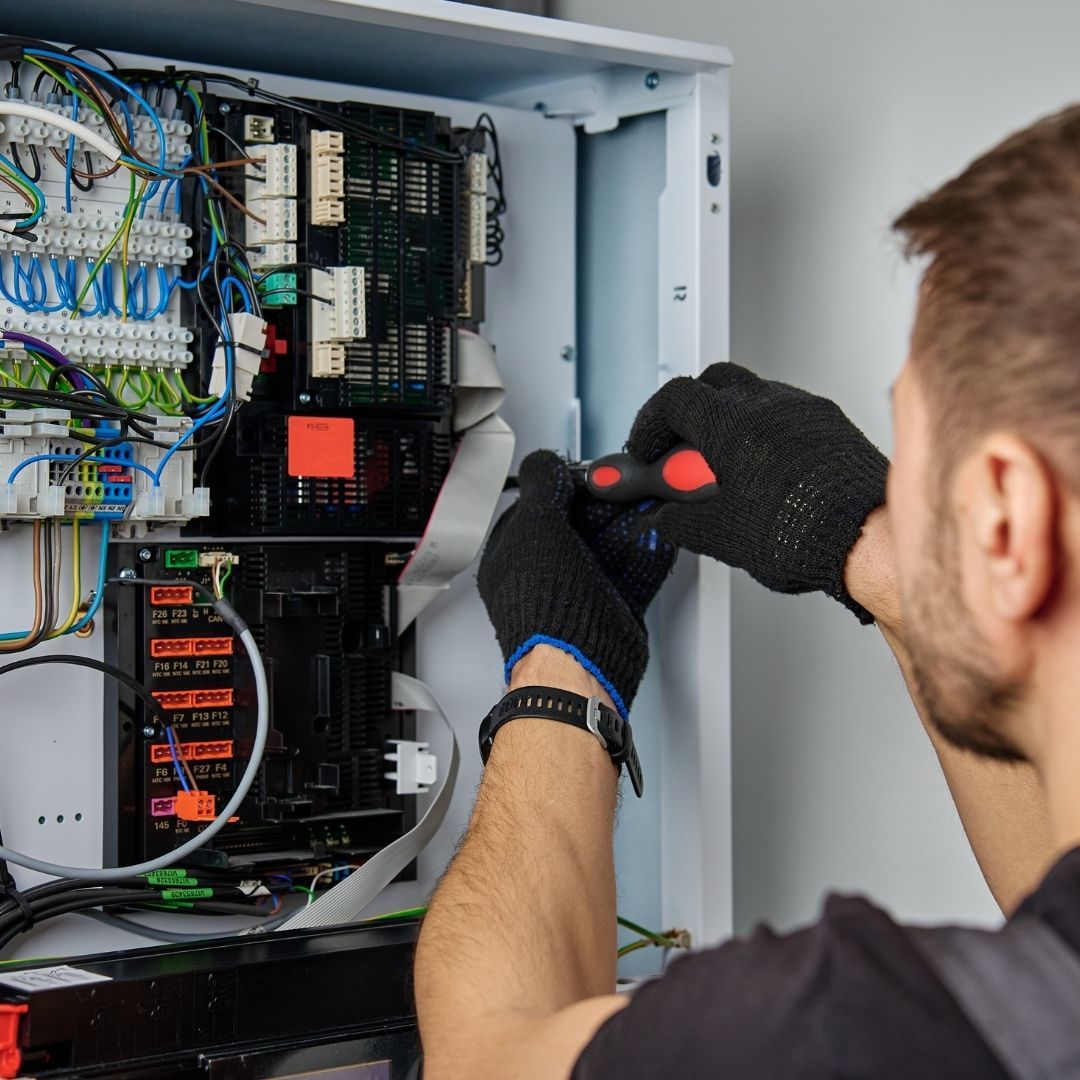 man servicing electrical panel