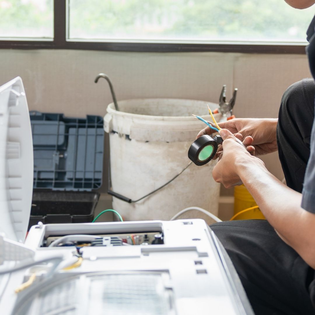 person servicing electric panel of appliance