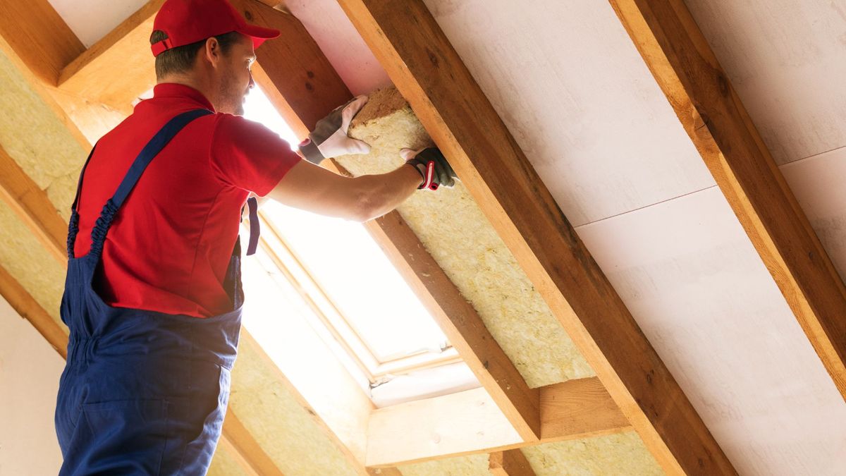 Contractor installing insulation in attic