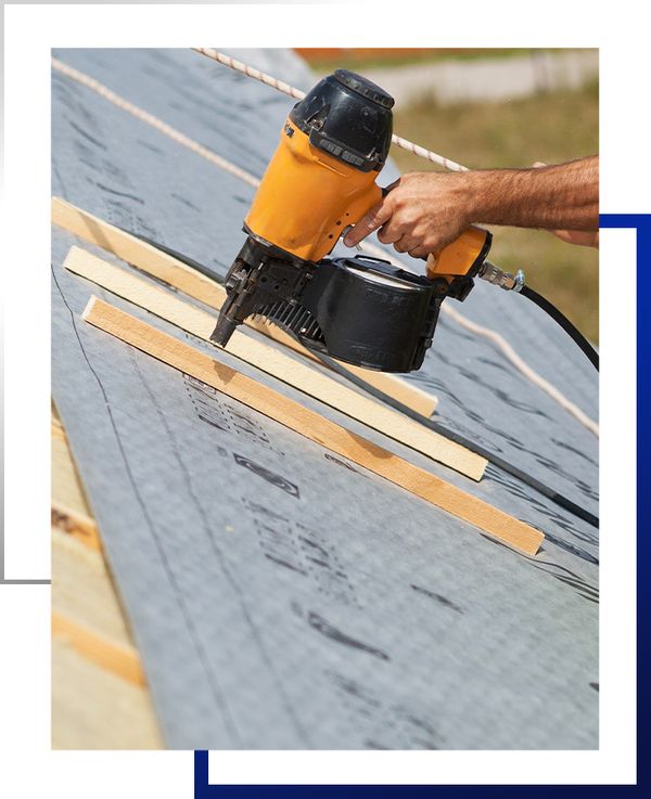 a person using a nail gun on a roof