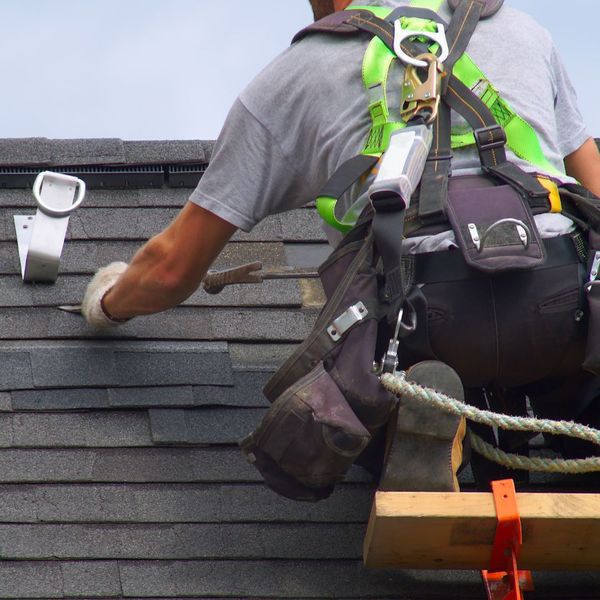 roofing contractor repairing shingles