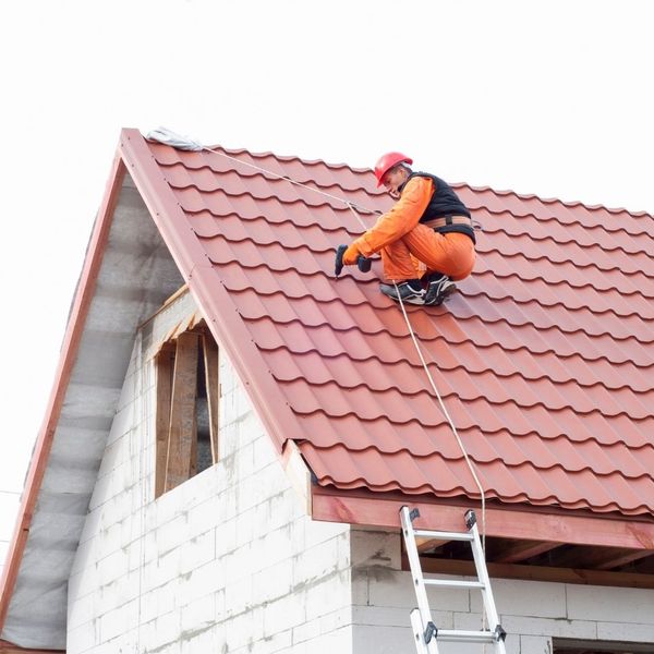 a roofer securing tiles to a roof