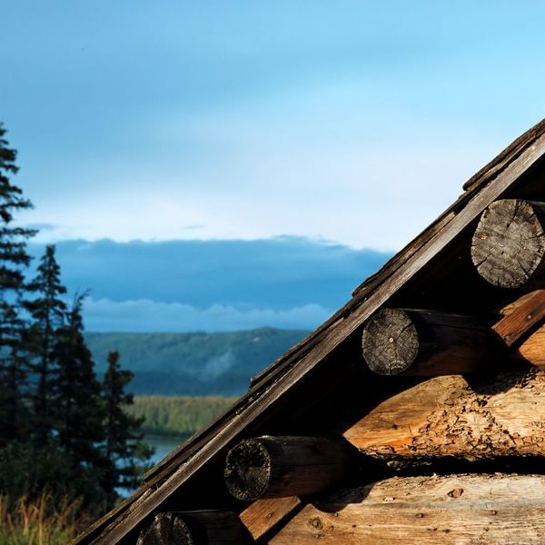 corner of a wooden cabin with mountains in the background