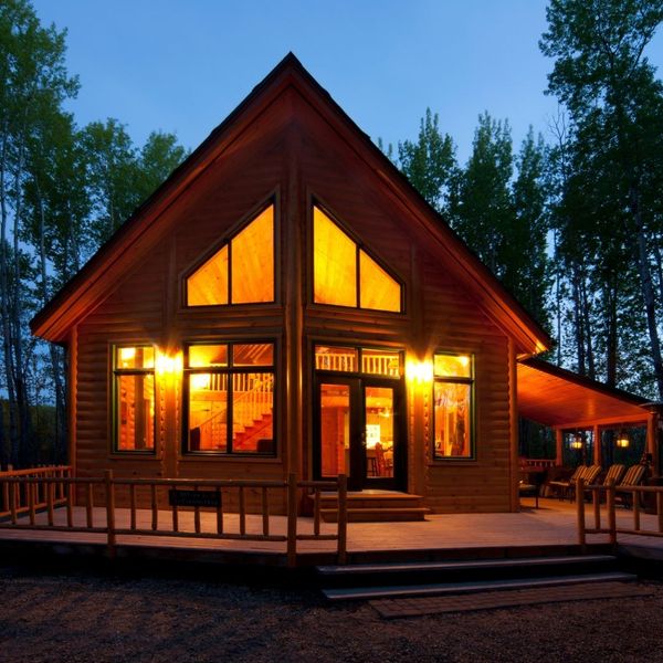 large cabin with windows glowing with light at night