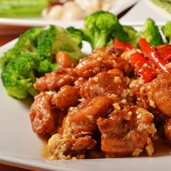 An image of garlic chicken with red peppers and broccoli.