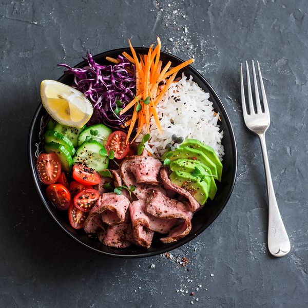 An image of a colorful salad with a fork sitting to the right of the bowl.