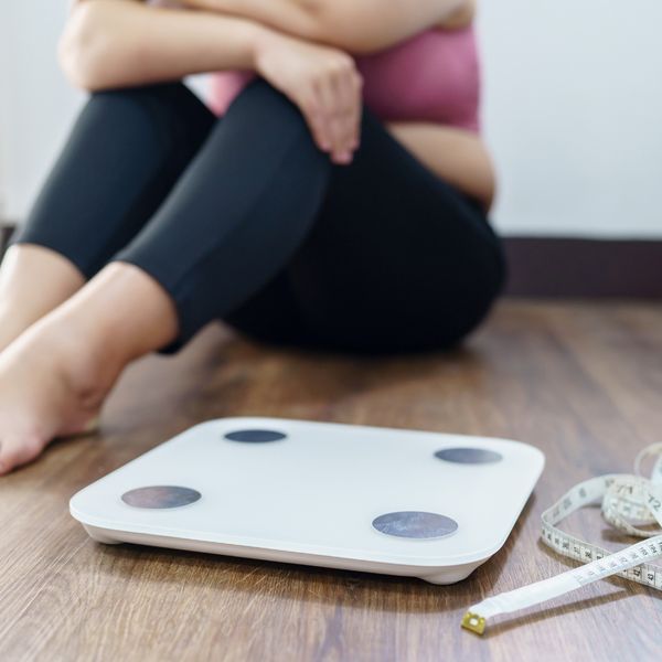 Woman sitting next to a scale