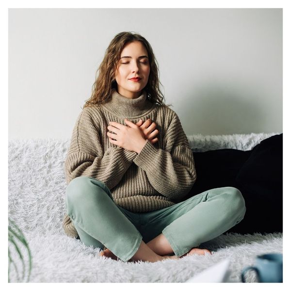 woman siting on couch breathing deeply