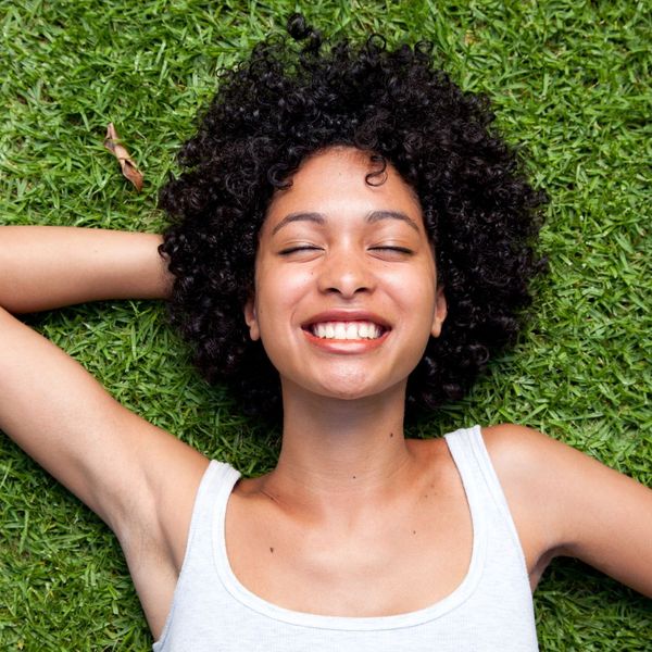 smiling woman laying in grass smiling woman laying in grass
