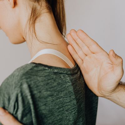A woman with a chiropractor's hand on her back