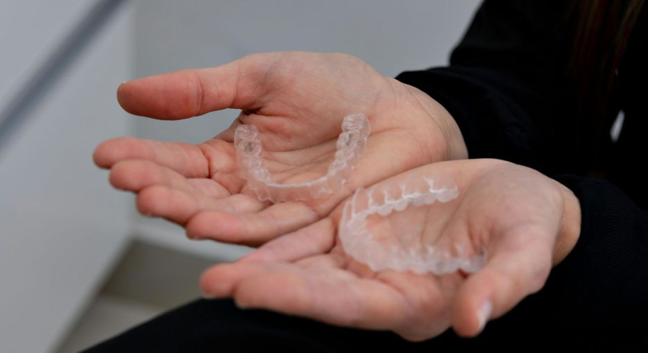 person holding invisalign trays