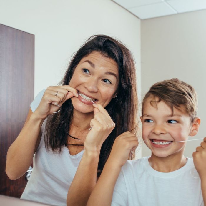 woman and child use dental floss How Does Stress Influence Gum Disease 4.jpg