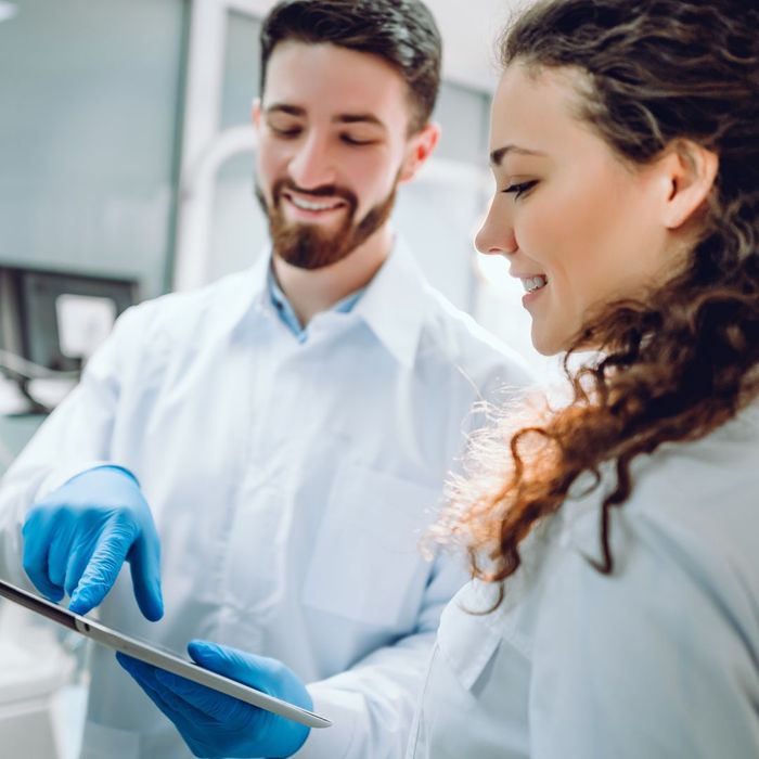 dentists in white coats look at tablet screen together How Dental Implants Can Improve Your Quality of Life 2.jpg