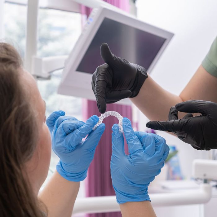 Dentist and patient look at Invisalign aligners Dentist and patient look at Invisalign aligners