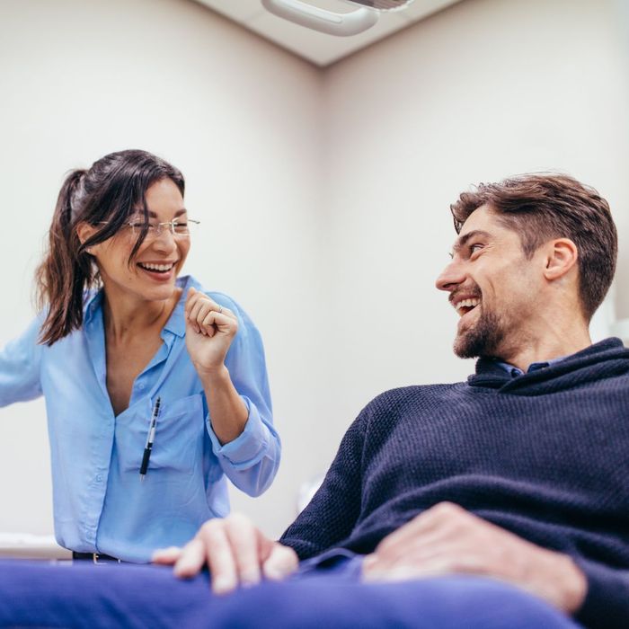 woman smiles next to patient sitting in chair How Can Routine Dental Check-Ups Save You Money 1.jpg