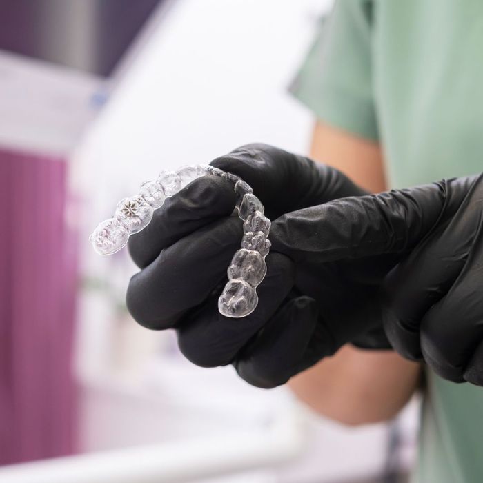 dentist holds Invisalign aligners dentist holds Invisalign aligners