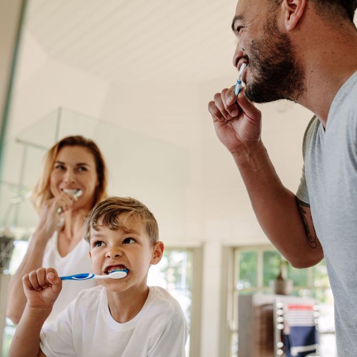 family brushes teeth together in bathroom Aesthetic Advantage of Invisalign 3.jpg