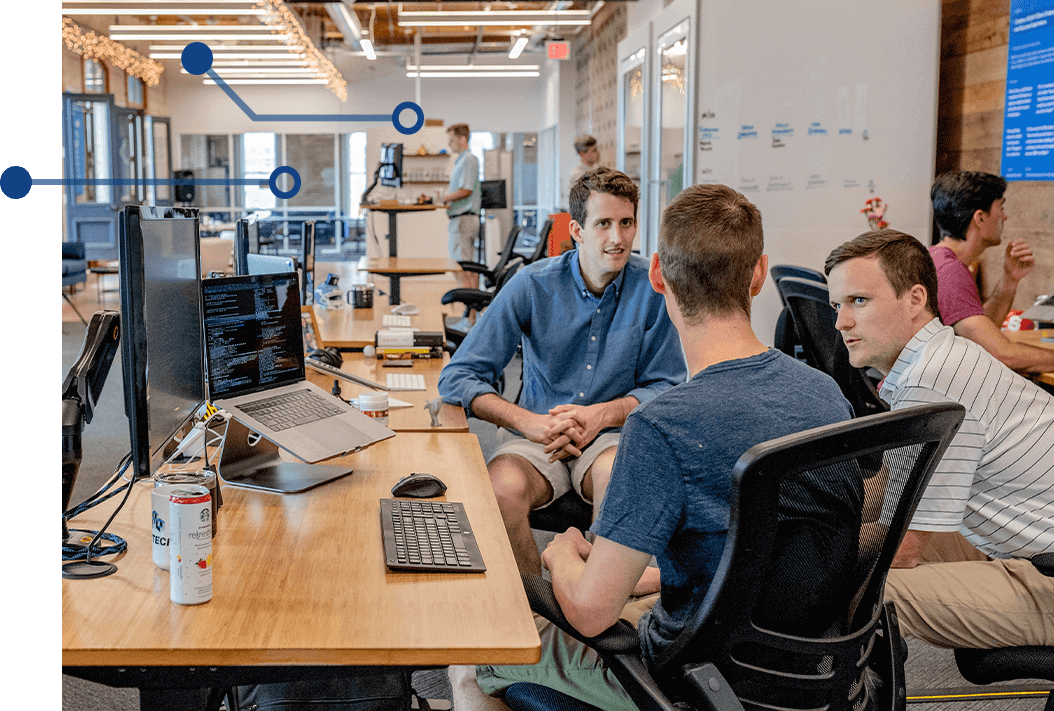 Men having discussion around computer workstation