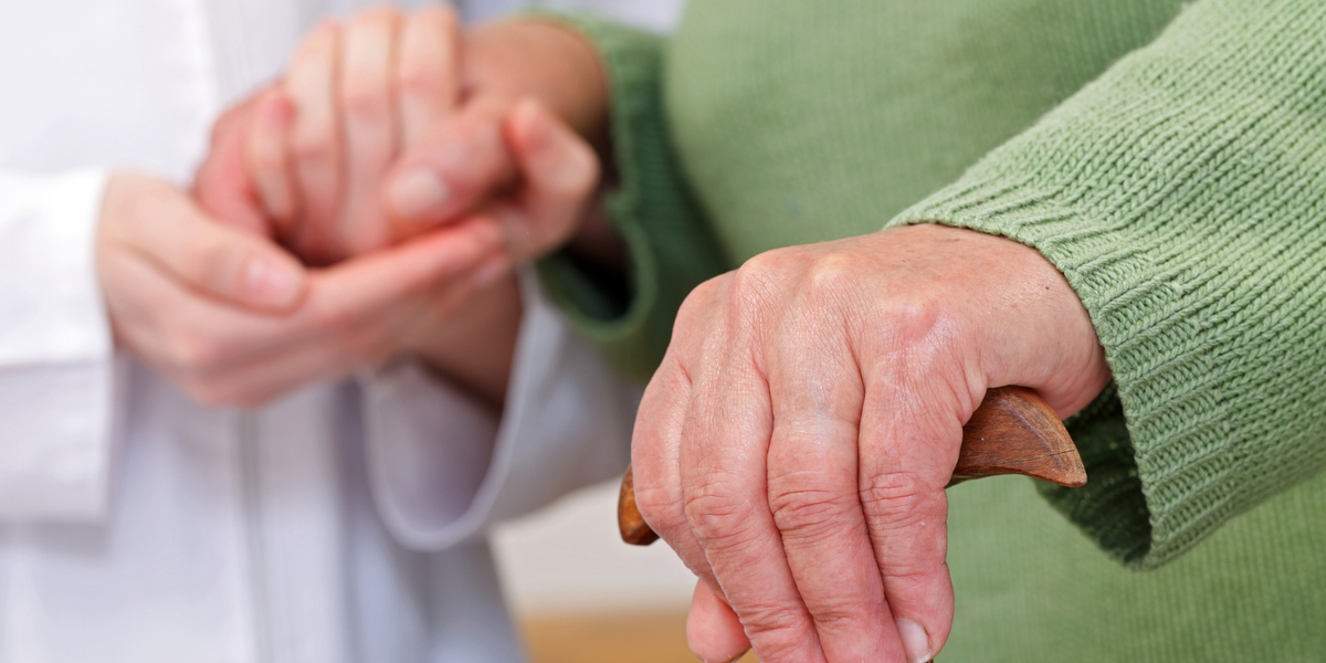 close up of elderly hands on cane