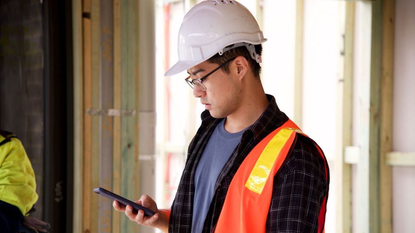 construction worker looking at phone