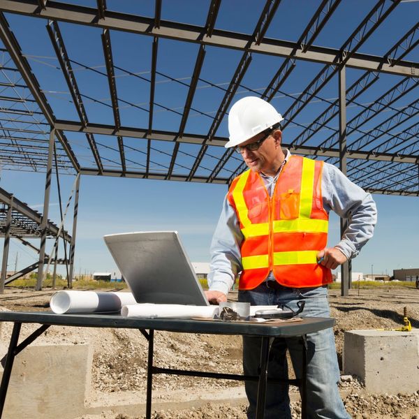construction worker looking at laptop computer