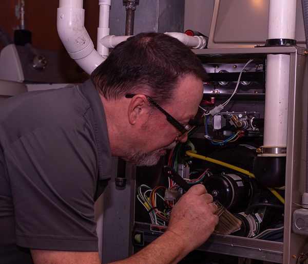 Image of a man repairing a heating system