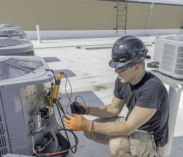 Image of a worker inspecting an ac unit