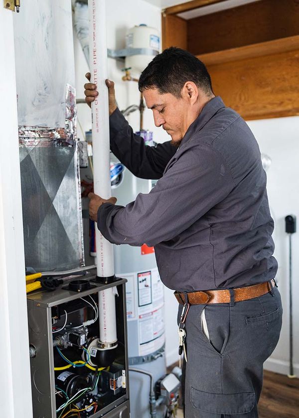 Image of a repair man working on a heating unit