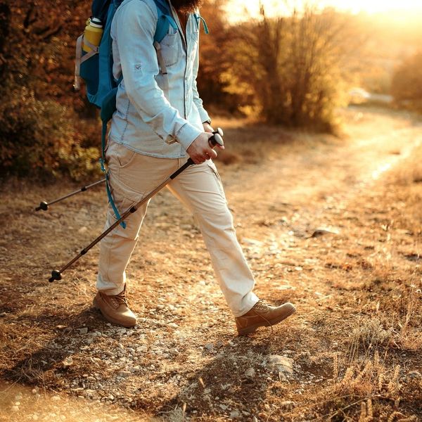 a man walking in nature with a walking stick