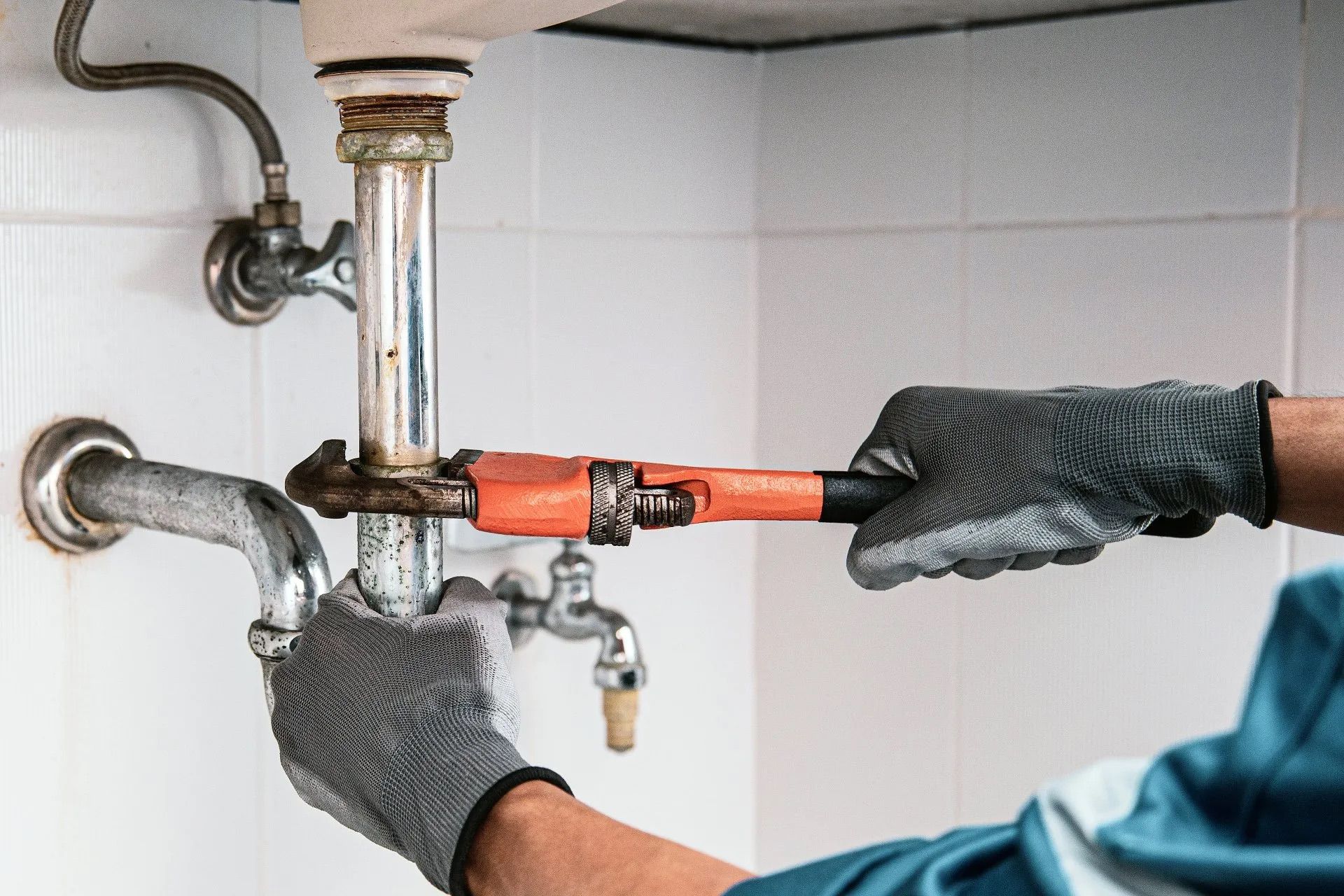 Plumber wrenching on a pipe