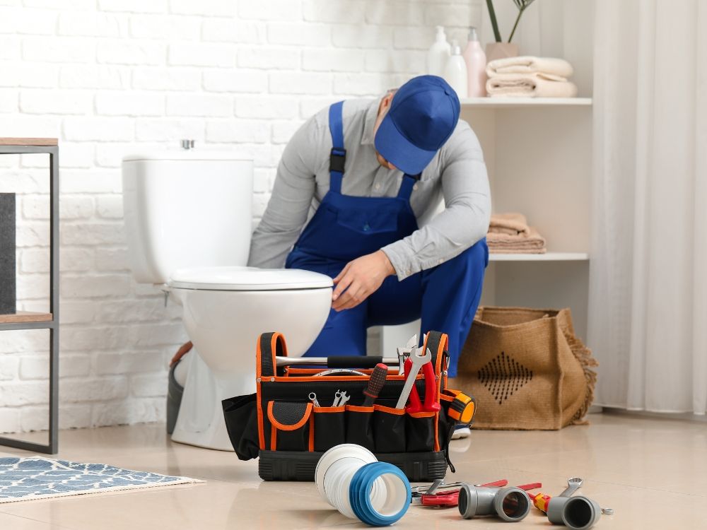 A plumber fixing a toilet