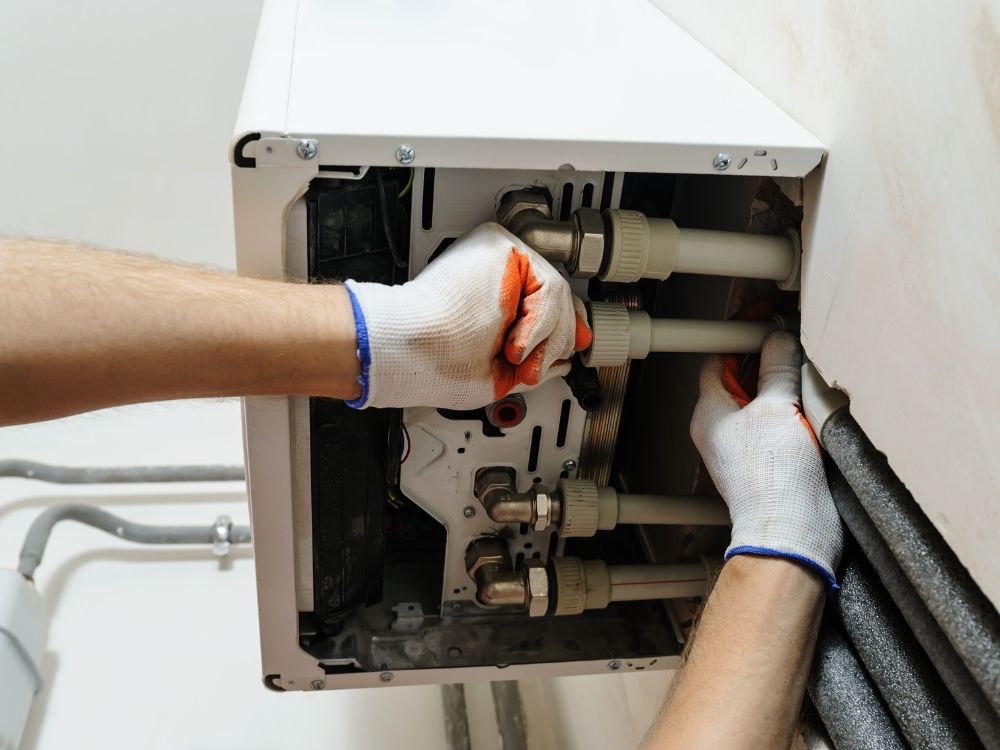 A plumber working on a water heater